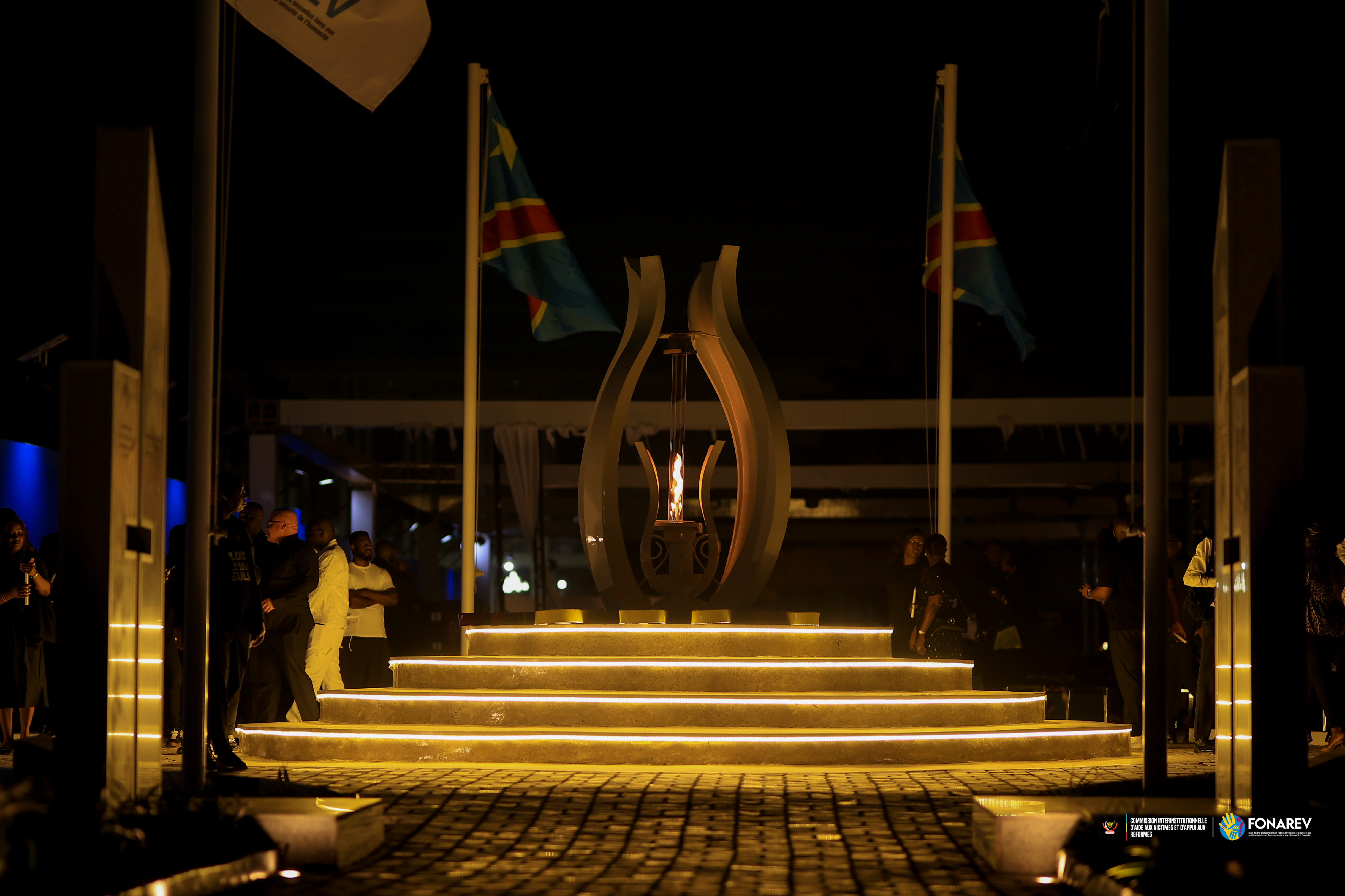 Visiteurs congolais marchant dans un lieu mémoriel contemporain aux matières minérales.