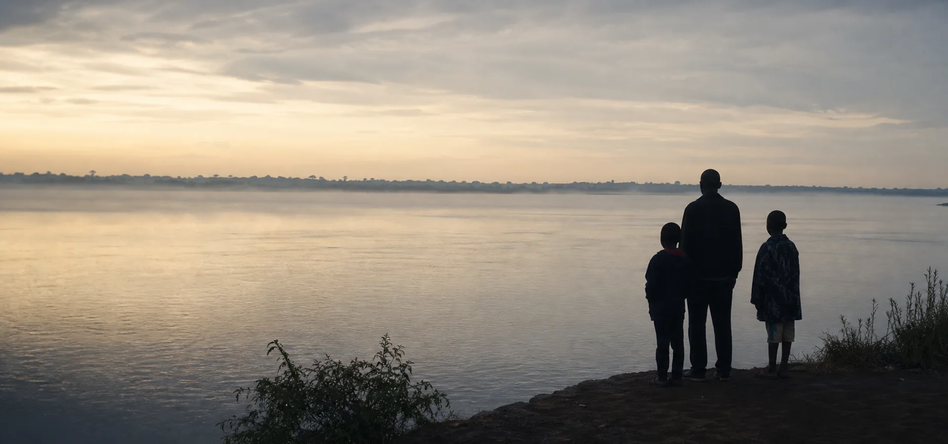 Un adulte et deux enfants face au fleuve Congo